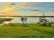 Scenic lake view at sunset with a charming dock, American flag, and lush green grass at 5005 Shore Side Dr, Lakeland, FL 33812