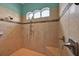Spacious tiled shower featuring a decorative tile accent, bench, and arched window at 5005 Shore Side Dr, Lakeland, FL 33812