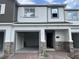Two-story townhome with stone accents, light gray siding, an open garage and front door at 5087 Prairie Preserve Run, St Cloud, FL 34772