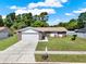 Attractive single-story home with large driveway, lush lawn, and charming curb appeal at 5210 Poinsetta Ave, Winter Park, FL 32792