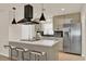 Modern kitchen featuring stainless steel refrigerator, pendant lights, island and black backsplash at 5210 Poinsetta Ave, Winter Park, FL 32792