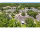 An aerial view shows the property with its screened in patio and manicured landscaping, near a lake at 533 Mount Olympus Blvd, New Smyrna Beach, FL 32168