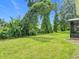 Spacious backyard featuring a lush green lawn and mature trees, creating a private outdoor space at 533 Mount Olympus Blvd, New Smyrna Beach, FL 32168