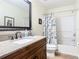 Bathroom with a dark wood vanity, granite countertop, framed mirror, and a shower-tub combo with nautical curtain at 533 Mount Olympus Blvd, New Smyrna Beach, FL 32168