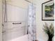 Clean bathroom features a shower with patterned curtain, a grab bar, and neutral colors at 533 Mount Olympus Blvd, New Smyrna Beach, FL 32168