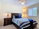 Cozy bedroom with a decorative comforter, a ceiling fan, and an end table with a lamp at 533 Mount Olympus Blvd, New Smyrna Beach, FL 32168