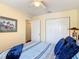 Comfortable bedroom featuring a neutral wall color, ceiling fan, closet, and a bed with blue and grey striped comforter at 533 Mount Olympus Blvd, New Smyrna Beach, FL 32168