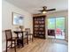 Dining area with a table and bookshelf next to sliding glass doors and laminate flooring at 533 Mount Olympus Blvd, New Smyrna Beach, FL 32168