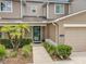 The front entrance of the townhome features well-manicured landscaping, leading up to a green front door at 533 Mount Olympus Blvd, New Smyrna Beach, FL 32168