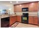 The kitchen features wooden cabinets, granite countertops, a black dishwasher, oven, and microwave at 533 Mount Olympus Blvd, New Smyrna Beach, FL 32168
