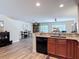 Open kitchen view showcases wood cabinets, granite countertops, laminate flooring and black dishwasher at 533 Mount Olympus Blvd, New Smyrna Beach, FL 32168