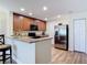 A kitchen features wooden cabinets, granite countertops, stainless steel refrigerator, and laminate flooring at 533 Mount Olympus Blvd, New Smyrna Beach, FL 32168