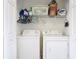 Laundry closet featuring a washer, a dryer, and wire shelves with cleaning supplies and laundry baskets at 533 Mount Olympus Blvd, New Smyrna Beach, FL 32168
