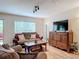 Living room features a couch, coffee table, and a large TV on a wood dresser, laminate flooring throughout at 533 Mount Olympus Blvd, New Smyrna Beach, FL 32168
