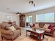 The living room features a sliding glass door, bookshelf, laminate flooring, couch and chairs at 533 Mount Olympus Blvd, New Smyrna Beach, FL 32168