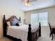 Comfortable main bedroom with a ceiling fan, a large window, and a decorative wooden bedframe at 533 Mount Olympus Blvd, New Smyrna Beach, FL 32168