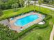 An aerial view showcases the beautiful community pool area with chairs, tables, and trimmed hedges at 533 Mount Olympus Blvd, New Smyrna Beach, FL 32168