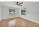 A bedroom featuring wood-look flooring, ceiling fan, and windows at 5460 Se 28Th St, Ocala, FL 34480