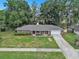 Charming one-story home features a spacious lawn, two-car garage, and red front door at 5460 Se 28Th St, Ocala, FL 34480