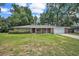 Charming one-story home features a spacious lawn, two-car garage, and red front door at 5460 Se 28Th St, Ocala, FL 34480