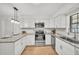 Bright kitchen features stainless steel appliances, white cabinetry, and granite countertops at 5460 Se 28Th St, Ocala, FL 34480