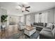 Open-concept living area with a gray sofa, wood floors, and ample natural light at 600 Plum Ln, Altamonte Springs, FL 32701