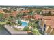 Aerial view of resort-style pool with palm trees, lounge chairs, and lush landscaping at 6149 Metrowest Blvd # 103, Orlando, FL 32835