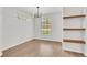 Inviting living room illuminated by a modern light fixture, with floating shelves and neutral walls at 6149 Metrowest Blvd # 103, Orlando, FL 32835