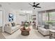 Bright living room with modern ceiling fan, open floor plan and light wood flooring at 6149 Metrowest Blvd # 103, Orlando, FL 32835
