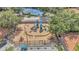This aerial view shows a fenced-in playground and tennis court within a Gathering-friendly community at 6149 Metrowest Blvd # 103, Orlando, FL 32835