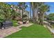 Outdoor patio area with a built-in grill, comfortable seating, and lush landscaping with lake access at 690 Osceola Ave # 410, Winter Park, FL 32789