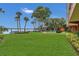 Expansive green backyard featuring tropical landscaping, leading to a lakefront with a pier at 690 Osceola Ave # 410, Winter Park, FL 32789