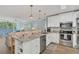 Bright kitchen boasts stainless steel appliances, granite countertops, and a breakfast bar overlooking the adjacent living area at 690 Osceola Ave # 410, Winter Park, FL 32789