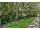 Beautifully landscaped backyard with lush greenery and a brick walkway leading to the water at 690 Osceola Ave # 410, Winter Park, FL 32789