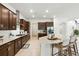 Gourmet kitchen with dark cabinetry, quartz countertops, stainless steel appliances, and breakfast bar seating at 7613 Wandering Way, Orlando, FL 32836
