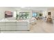 Spacious living room featuring a large white sofa, open floorplan, and sliding glass doors to the pool at 7613 Wandering Way, Orlando, FL 32836