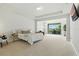 Bright main bedroom boasts tray ceiling, seating area, and sliding glass doors to the balcony at 7613 Wandering Way, Orlando, FL 32836