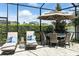 Outdoor pool area with dining table, lounge chairs, and manicured hedges at 7613 Wandering Way, Orlando, FL 32836