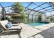 Screened-in pool area with lounge chairs and outdoor dining, perfect for relaxation at 7613 Wandering Way, Orlando, FL 32836