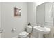 Chic powder room featuring a pedestal sink, decorative mirror, and stylish fixtures with neutral color palette at 7613 Wandering Way, Orlando, FL 32836