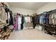 Spacious walk-in closet with ample storage for clothes, shoes and accessories with custom shelving and carpeted floor at 7613 Wandering Way, Orlando, FL 32836