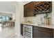 Stylish wet bar with wine storage, beverage cooler, and elegant countertop at 7613 Wandering Way, Orlando, FL 32836