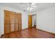 Comfortable bedroom featuring wood floors, closet space, and a ceiling fan with a simple light fixture at 8665 Vista Point Cv, Orlando, FL 32836