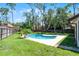 This home includes a pool with lush landscaping, a privacy fence, and many tall trees at 8665 Vista Point Cv, Orlando, FL 32836
