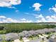 This aerial shot looks over homes near a large forested area, under a sky filled with fair-weather clouds at 9426 Launch Point Rd, Orlando, FL 32832