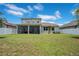 Expansive backyard with lush green grass, screened lanai, and privacy fence at 9426 Launch Point Rd, Orlando, FL 32832