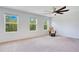Spacious carpeted bedroom featuring a ceiling fan, bright windows, and neutral paint at 9426 Launch Point Rd, Orlando, FL 32832