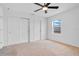 A neutrally painted bedroom with carpeted floors, a double door closet and a window at 9426 Launch Point Rd, Orlando, FL 32832