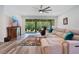 Comfortable living room featuring a ceiling fan, plush sofa, and access to a screened patio at 9426 Launch Point Rd, Orlando, FL 32832