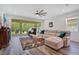Cozy living room with a large sofa, colorful rug, and view of the outdoor screened patio at 9426 Launch Point Rd, Orlando, FL 32832